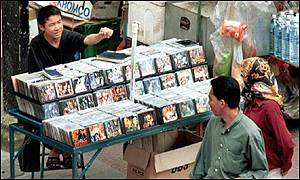 Pavement vendor in Malaysia selling pirated CDs and videos