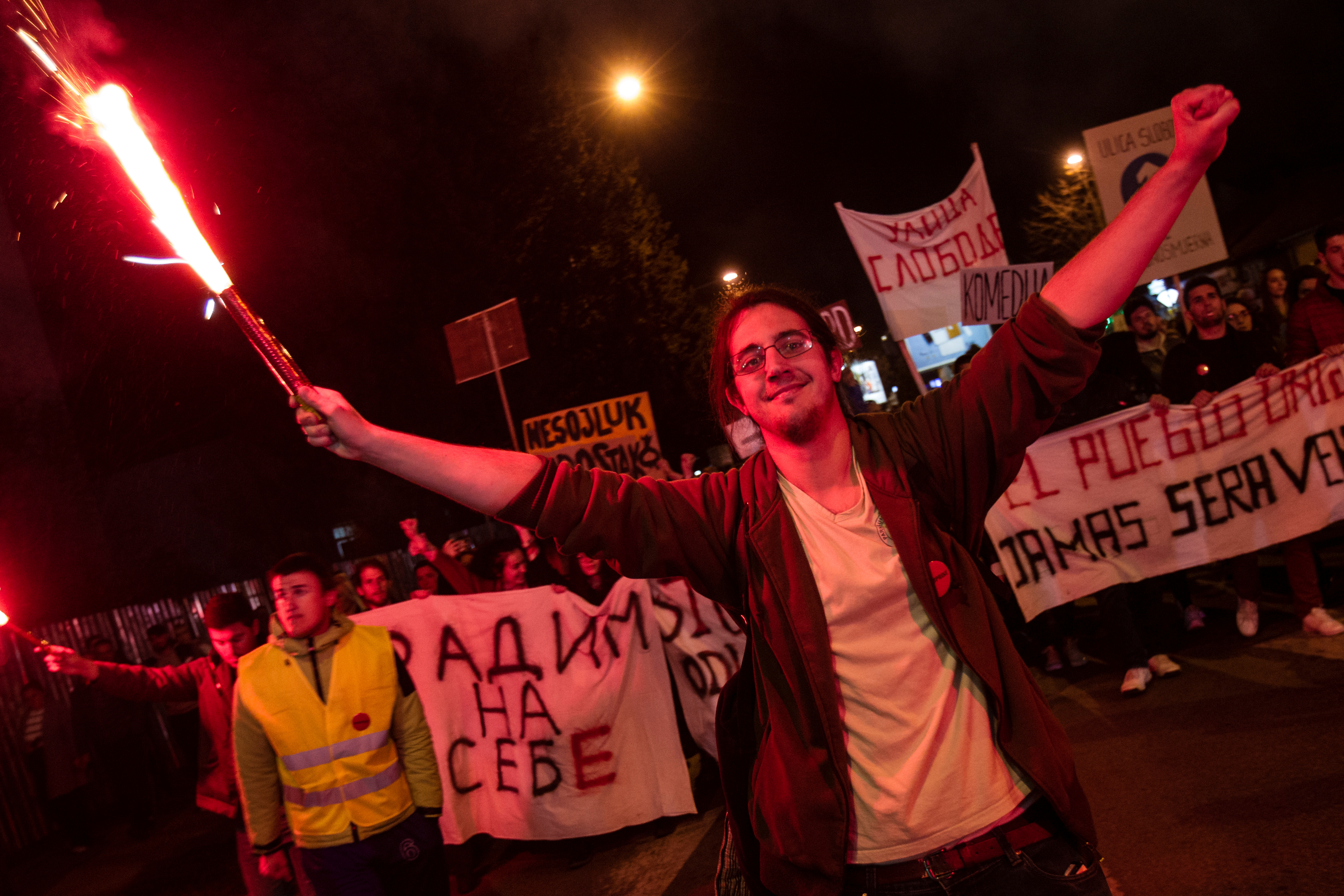A demonstrator holds a flare during civic protest in Podgorica