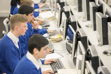 Students in school uniform working on computers