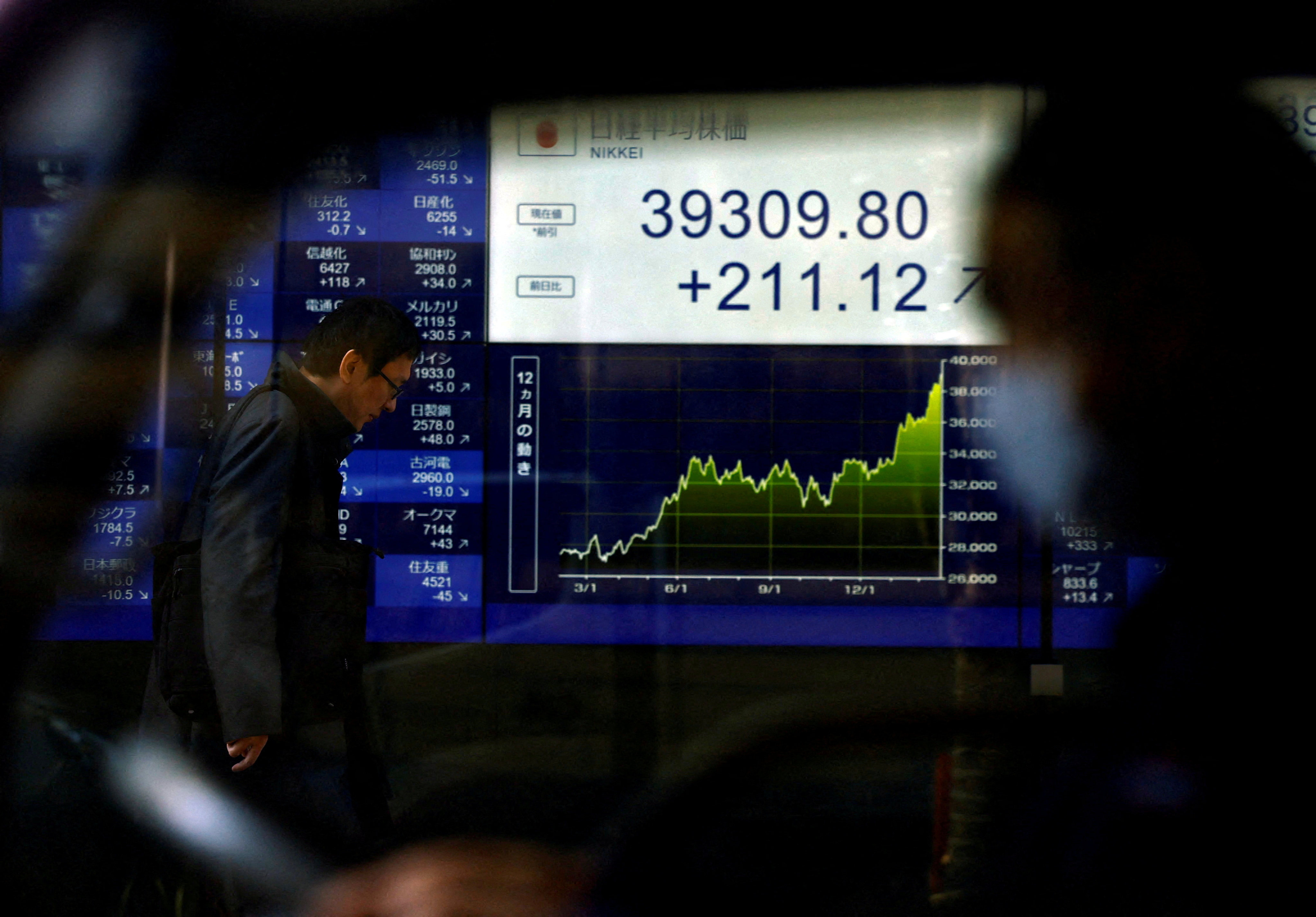 An electronic screen displays Japan’s Nikkei index as the share average hits a record high in Tokyo on February 26. We should be re-examining the role of private and public sectors in allocating financial resources to the global economy. Photo: Reuters