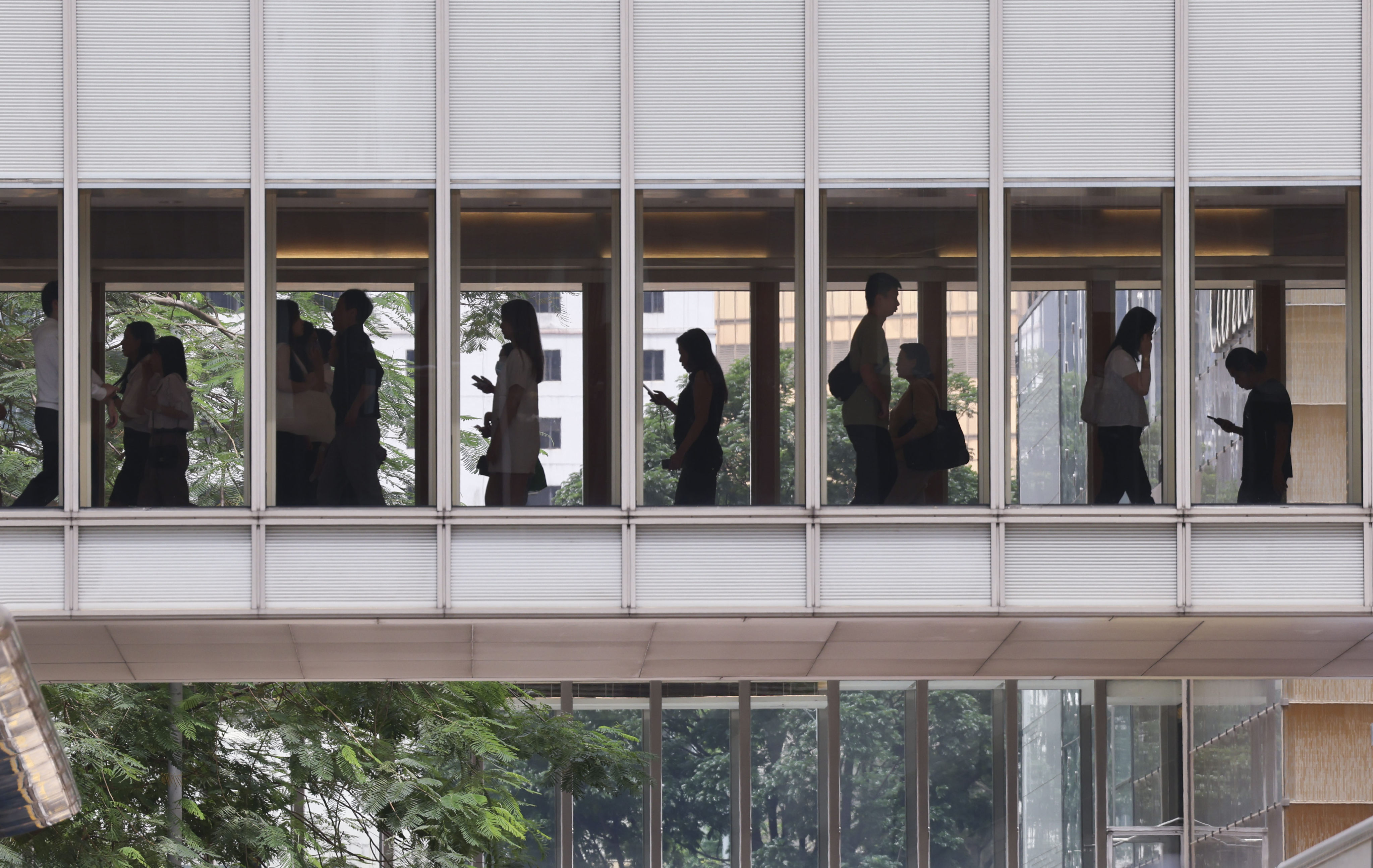 People walk on a footbridge in Central during lunch time. More than half of Hong Kong employees are at risk or struggling with respect to their finances, according to a survey by advisory firm WTW. Photo: Jelly Tse