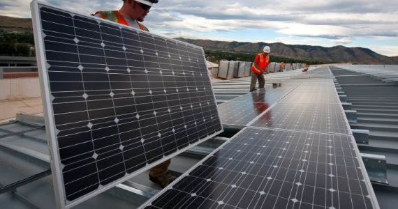 Photo of people installing solar panels.