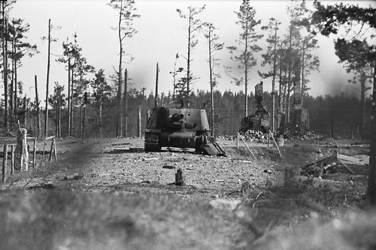 A Russian tank in position in front of a burned-out rural post office (background).