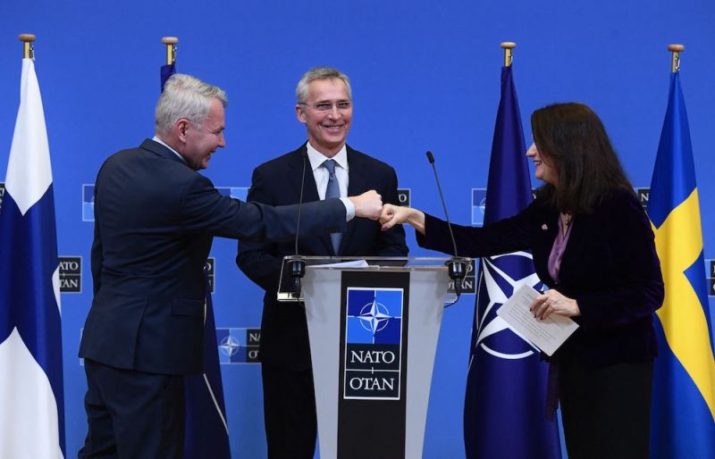 NATO Secretary General Jens Stoltenberg looks on as Finland Ministers for Foreign Affairs Pekka Haavisto (L) and Sweden Foreign minister Ann Linde (R) bump fists after holding a joint press conference after their meeting at the NATO headquarters in Brussels on Jan. 24, 2022.