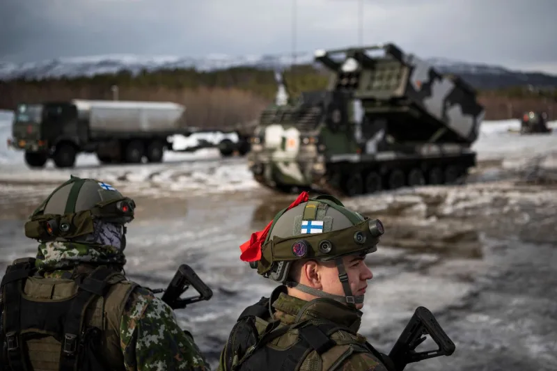 Soldiers from the Finnish Defence Forces stand in front of a M270 Multiple Launch Rocket System during the international military exercise Cold Response 22, at Setermoen, Norway, on March 22.