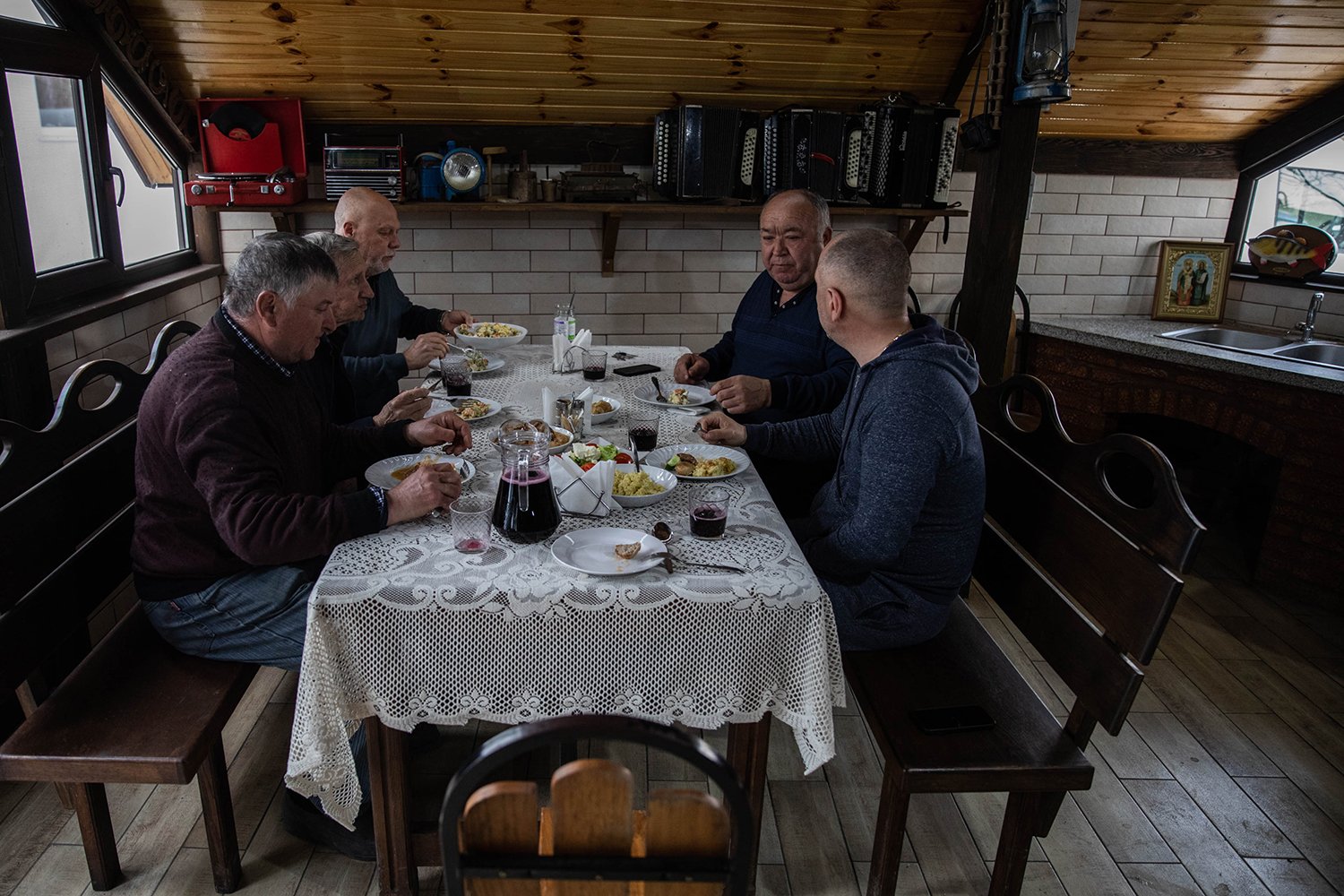 Gheorghe Diaconu, who co-owns the La Costesti tourist resort, shares dinner with displaced men from Ukraine.