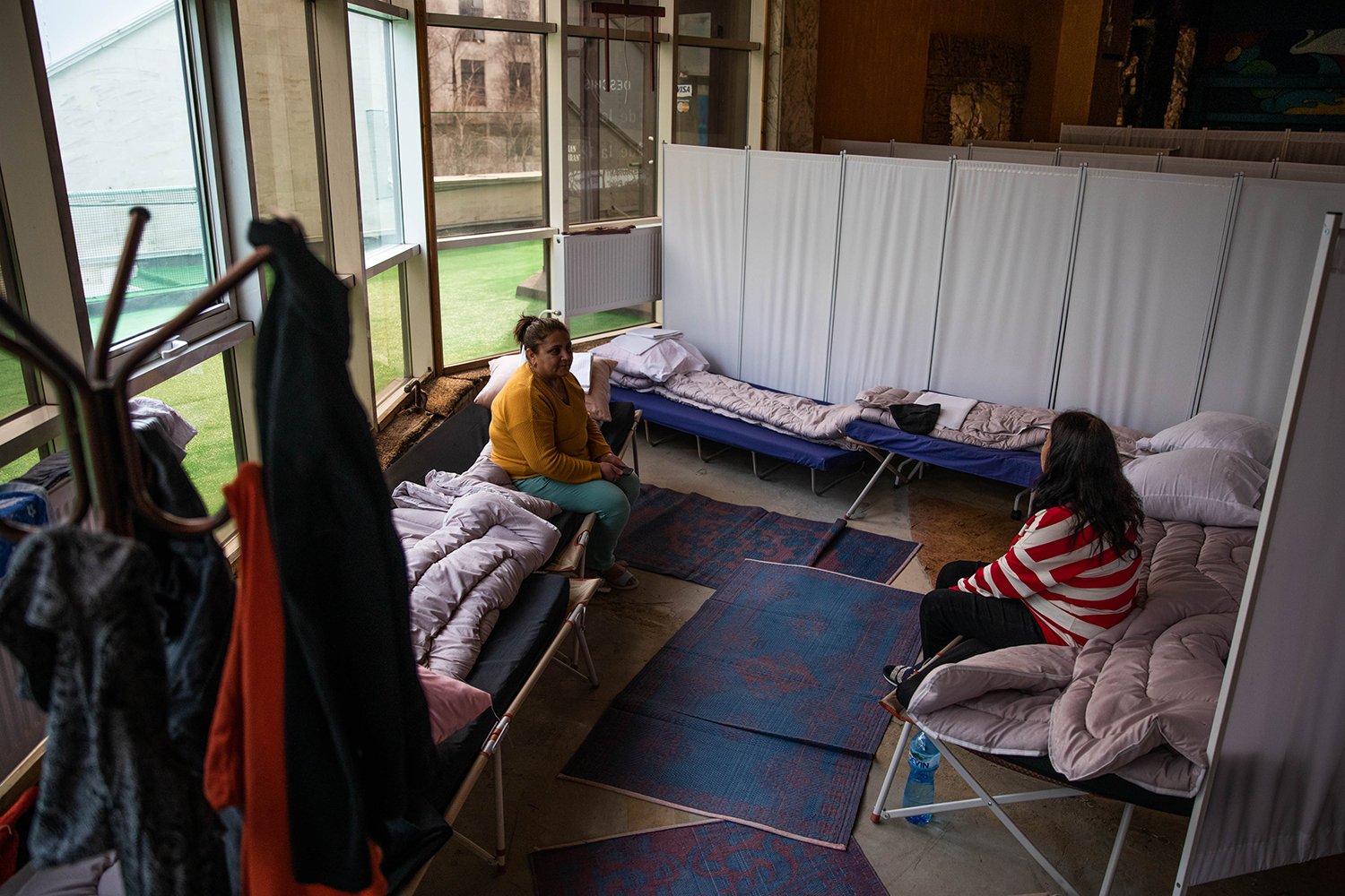 Women sit on beds inside a shelter for Ukrainian refugees in Moldova.