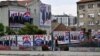 Žena prolazi pored predizbornih bilborda na kojima su predstavljeni predsednik Srbije Aleksandar Vučić i drugi funkcioneri Srpske napredne stranke (SNS) u Beogradu 31. maja 2024, pre glasanja na lokalnim izborima.