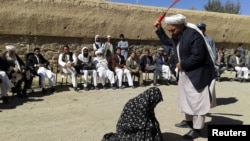 An Afghan judge hits a woman with a whip in front of a crowd in Ghor Province in 2015. (illustrative photo)