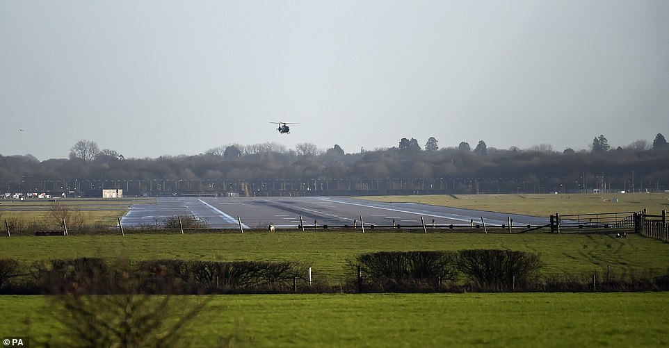 A helicopter flies over the runway at Gatwick Airport this morning after it was closed