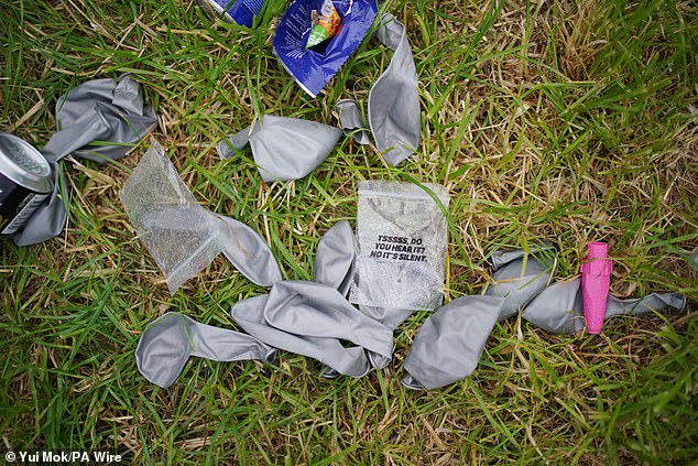 Discarded balloons left next to nitrous oxide canisters in a car park, at the Glastonbury Festival this morning