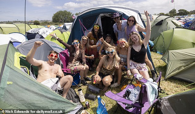 Glasto revellers huddle for a group photo outside their tents