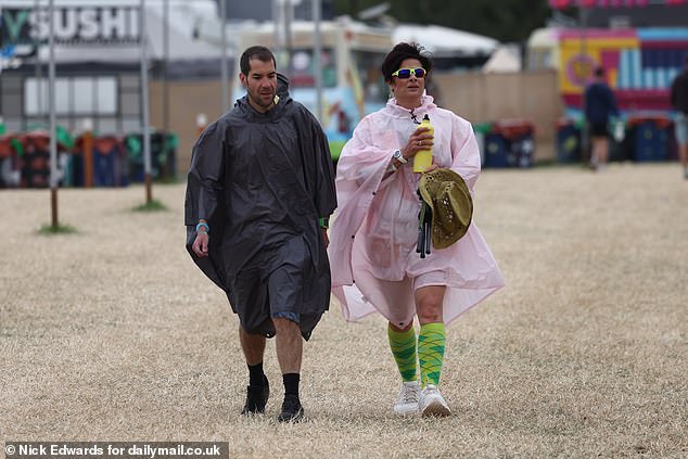 Revellers walk through the Glastonbury Festival site at Worthy Farm in Somerset this morning