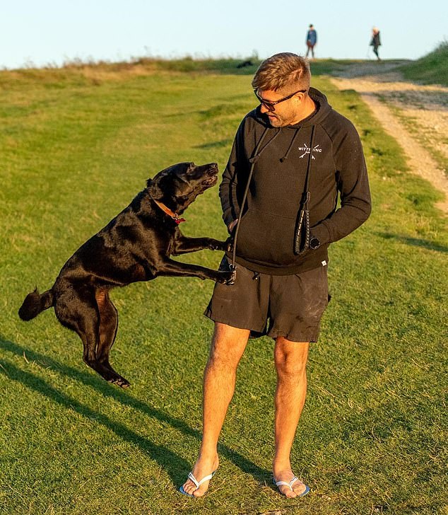 Mark is pictured playing with his family's couple's dog while sporting a black hoodie, shorts and sunglasses. His father Ray confirmed that his son was in a relationship with Joanne