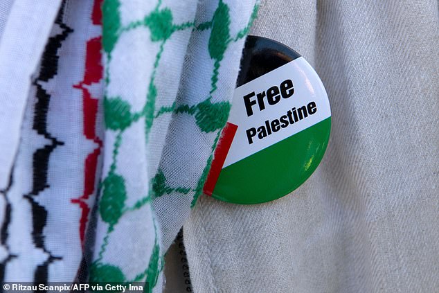 A stock image of a protester wearing a Free Palestine badge during a demonstration
