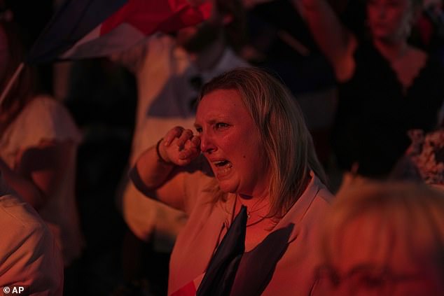 A supporter of French far right leader Marine Le Pen reacts after the release of projections based on the actual vote count in select constituencies