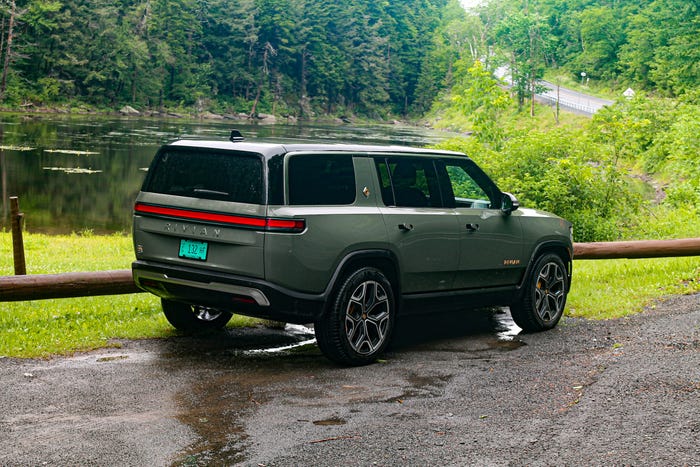 A green Rivian R1S electric SUV on a road