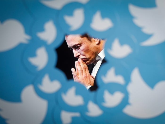 An image of new Twitter owner Elon Musk is seen surrounded by Twitter logos in this photo illustration.