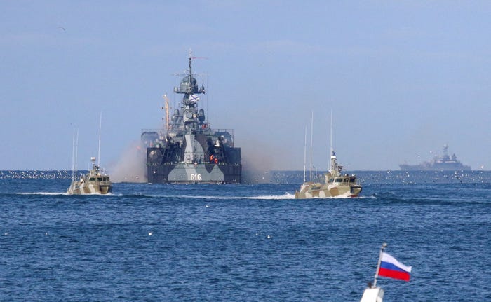 A large Russian vessel sailing in between two smaller vessels.