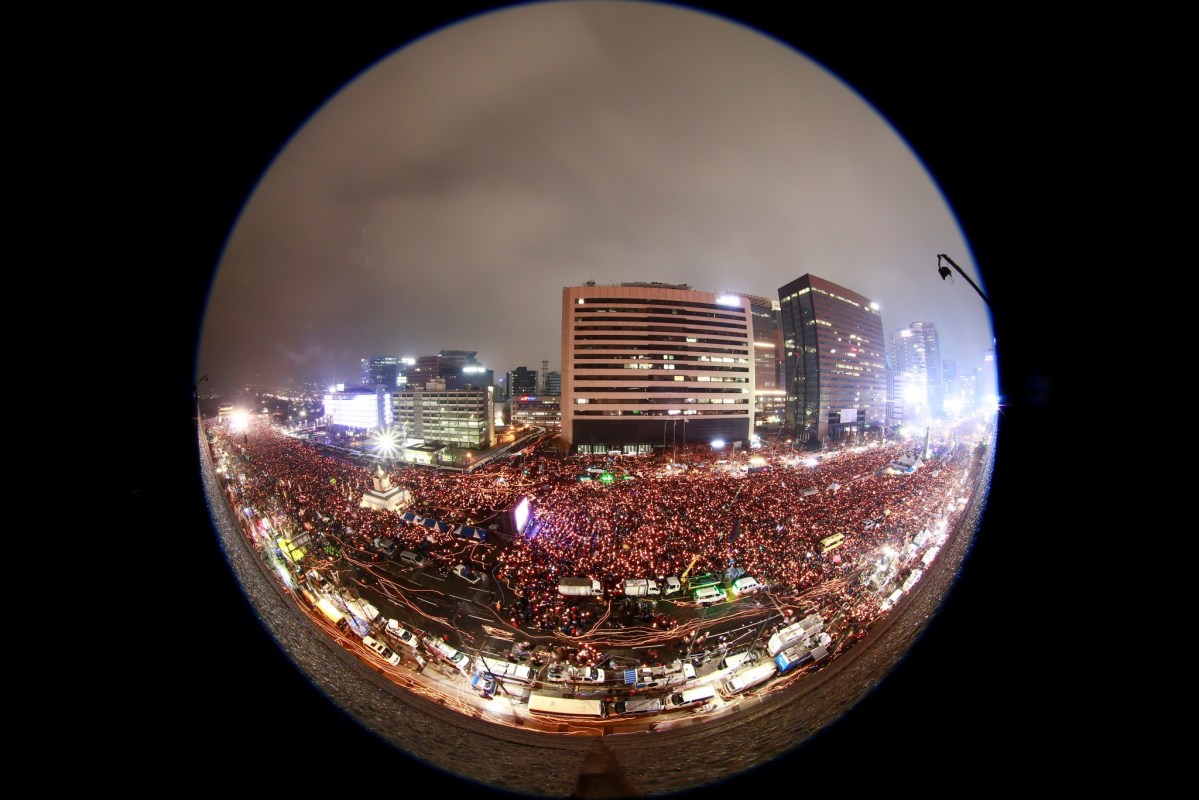 An image taken with a fish-eye lens shows South Koreans in a candlelight procession marching toward the presidential house during a rally against President Park Geun-Hye on a main street in Seoul, South Korea, 26 November 2016. Photo:  Reuters/Jeon Heon-kyun