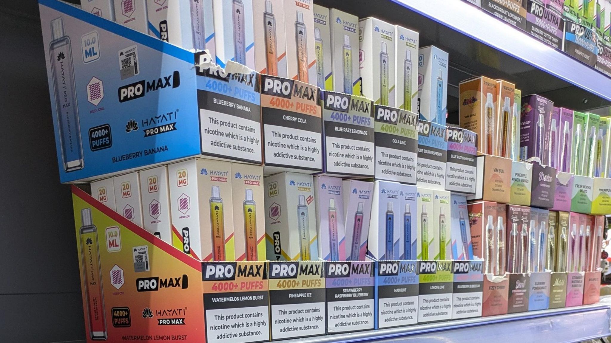 Two rows of stacked smoking vapes in their boxes which are an array of colours including orange, purple, blue, green and pink
