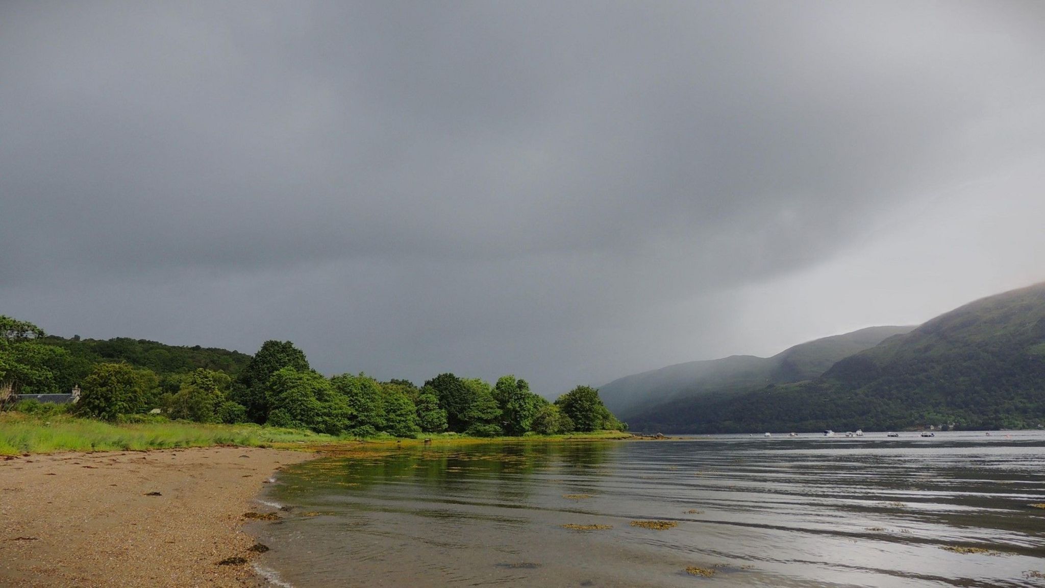 Water, trees, mountains and a dark sky in western Scotland