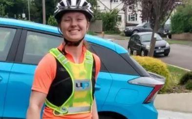 Emma Davis in cycling gear with fluorescent bib and black and white helmet about to set off for Paris