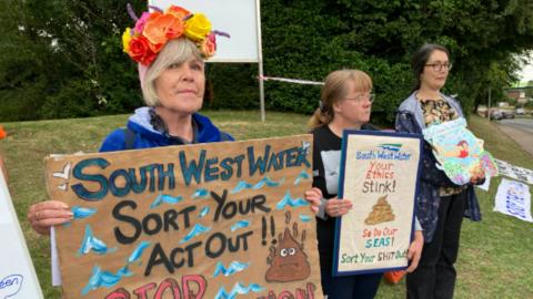 Campaigners outside Penisula House in Exeter holding placards criticising South West Water
