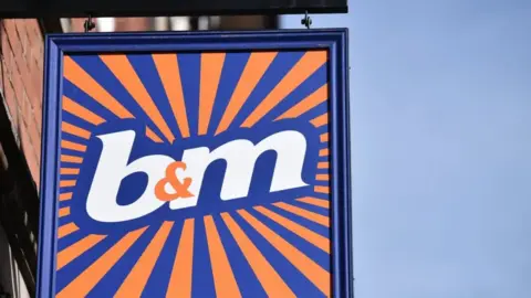 Blue and orange sign with "B&M" in the middle in white text