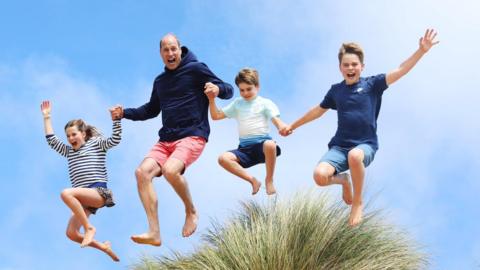 Prince William jumps in the air with his children