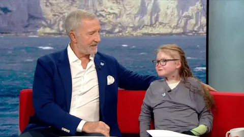Graeme Souness sits on the red BBC Breakfast sofa beside Isla Grist