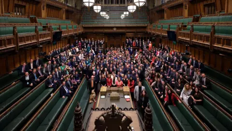 Reuters Members of Parliament, newly elected in the 2024 general election, gather in the House of Commons Chamber for a group photo