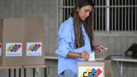 A woman casts her vote in Caracas, 28 July 2024