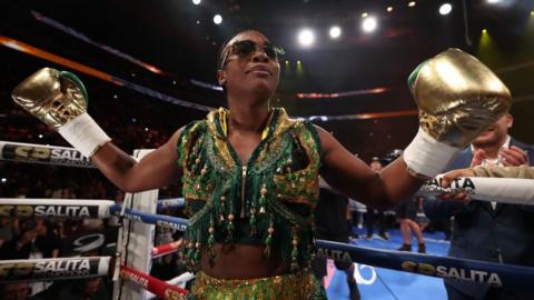 Claressa Shields is shades and a green, sparkling ringwalk outfit