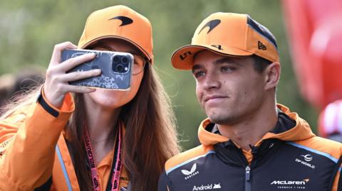 Lando Norris poses for a selfie with a fan