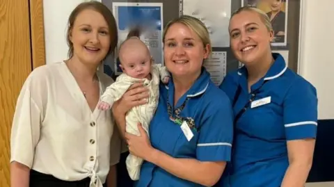 Nurse Lauren Duhig (centre) holds baby Isabella, next to Beth Paterson and nurse Megan Tidy