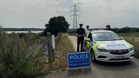George King/BBC Police officers and car on track in Brantham