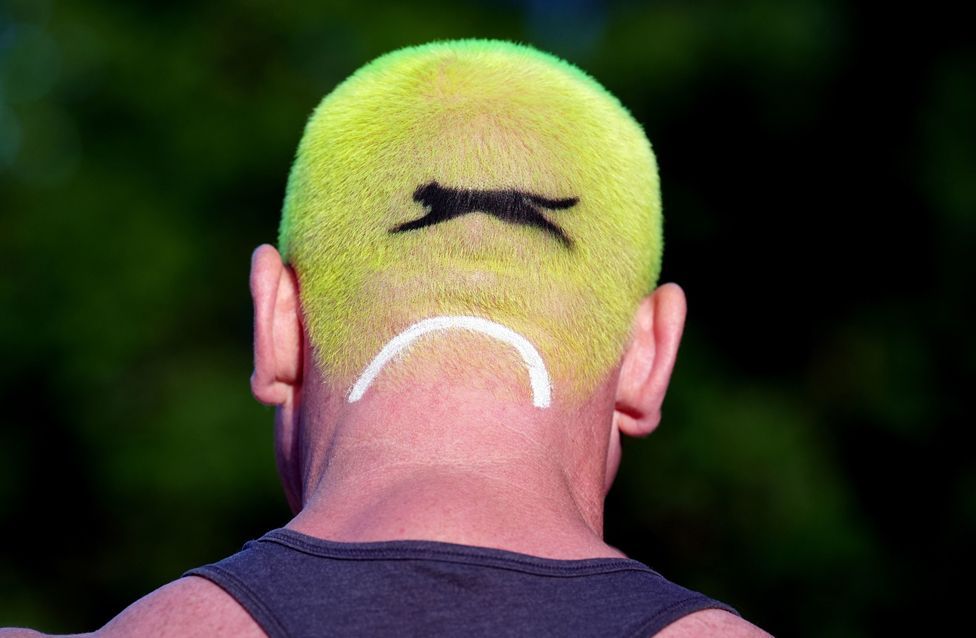 A person with hair in the style of a tennis ball, on day one of the 2024 Wimbledon Championships, London. 1 July 2024. 