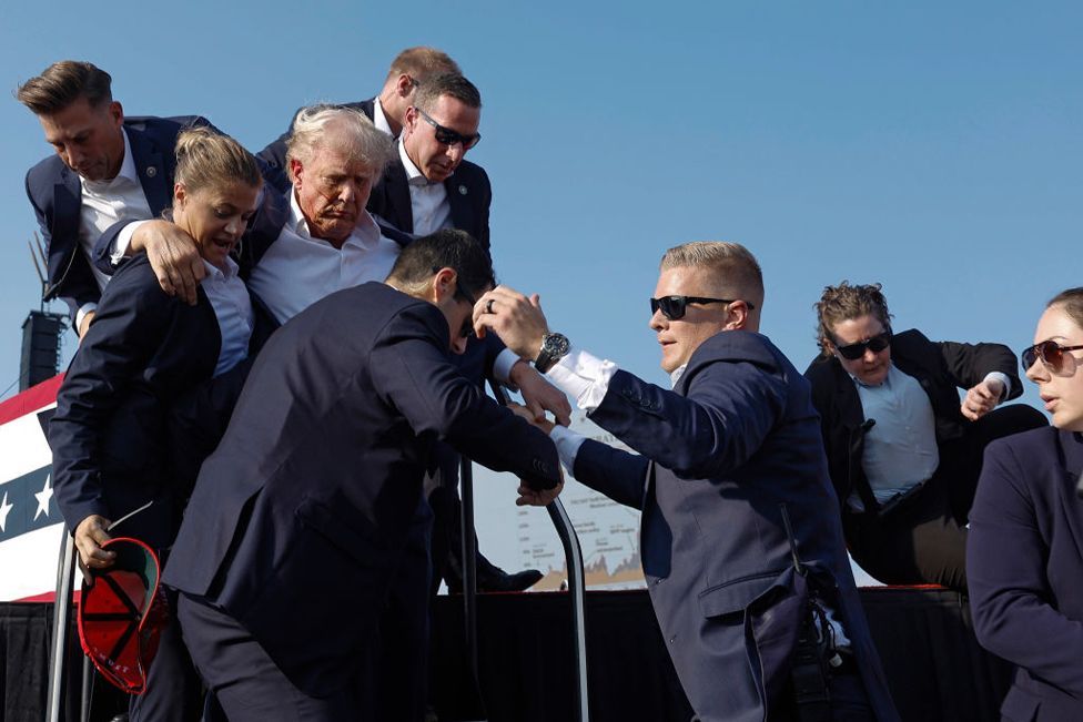 Republican presidential candidate former President Donald Trump is rushed offstage by U.S. Secret Service agents after being grazed by a bullet during a rally on July 13, 2024 in Butler, Pennsylvania. 