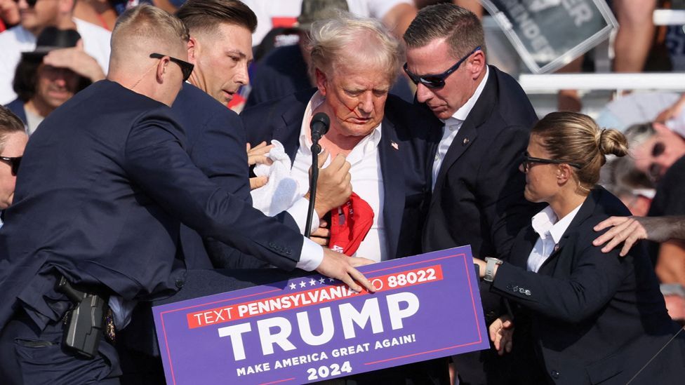 Republican presidential candidate and former U.S. President Donald Trump is assisted by the Secret Service after gunfire rang out during a campaign rally at the Butler Farm Show in Butler, Pennsylvania, U.S., July 13, 2024. 