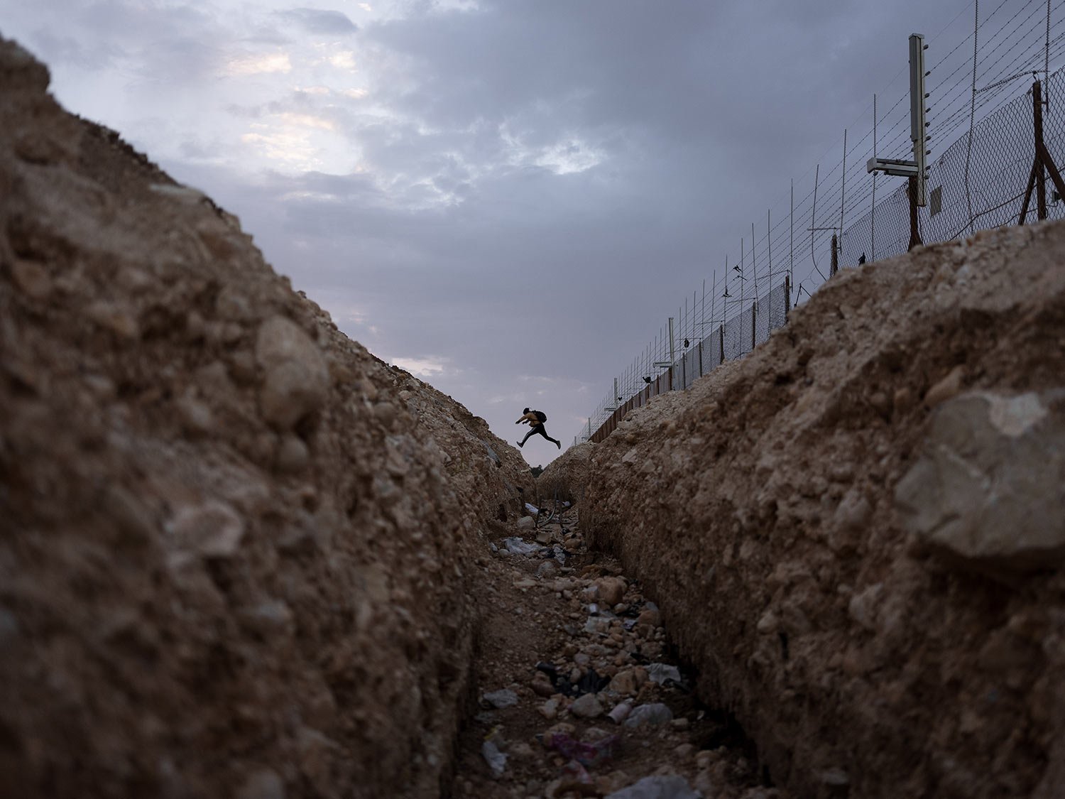  A Palestinian crosses into Israel from the West Bank through an opening in the Israeli separation barrier near Meitar crossing south of West Bank, March 6, 2022. (AP Photo/Oded Balilty) 