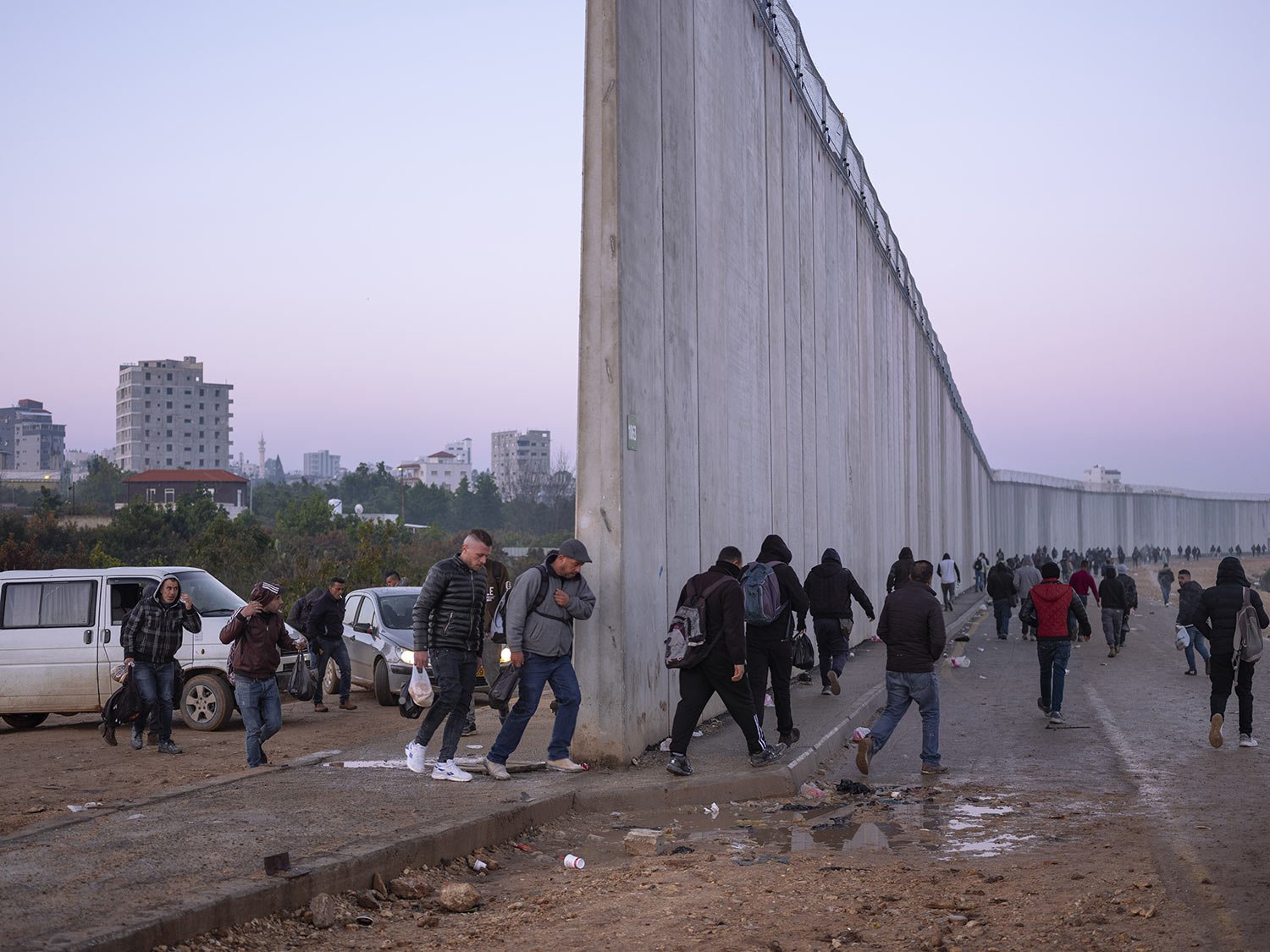  Palestinians cross into Israel from the West Bank through an opening in the Israeli separation barrier between the West Bank town of Qalqilya and the Israeli Kibbutz Eyal, Feb. 27, 2022. (AP Photo/Oded Balilty) 