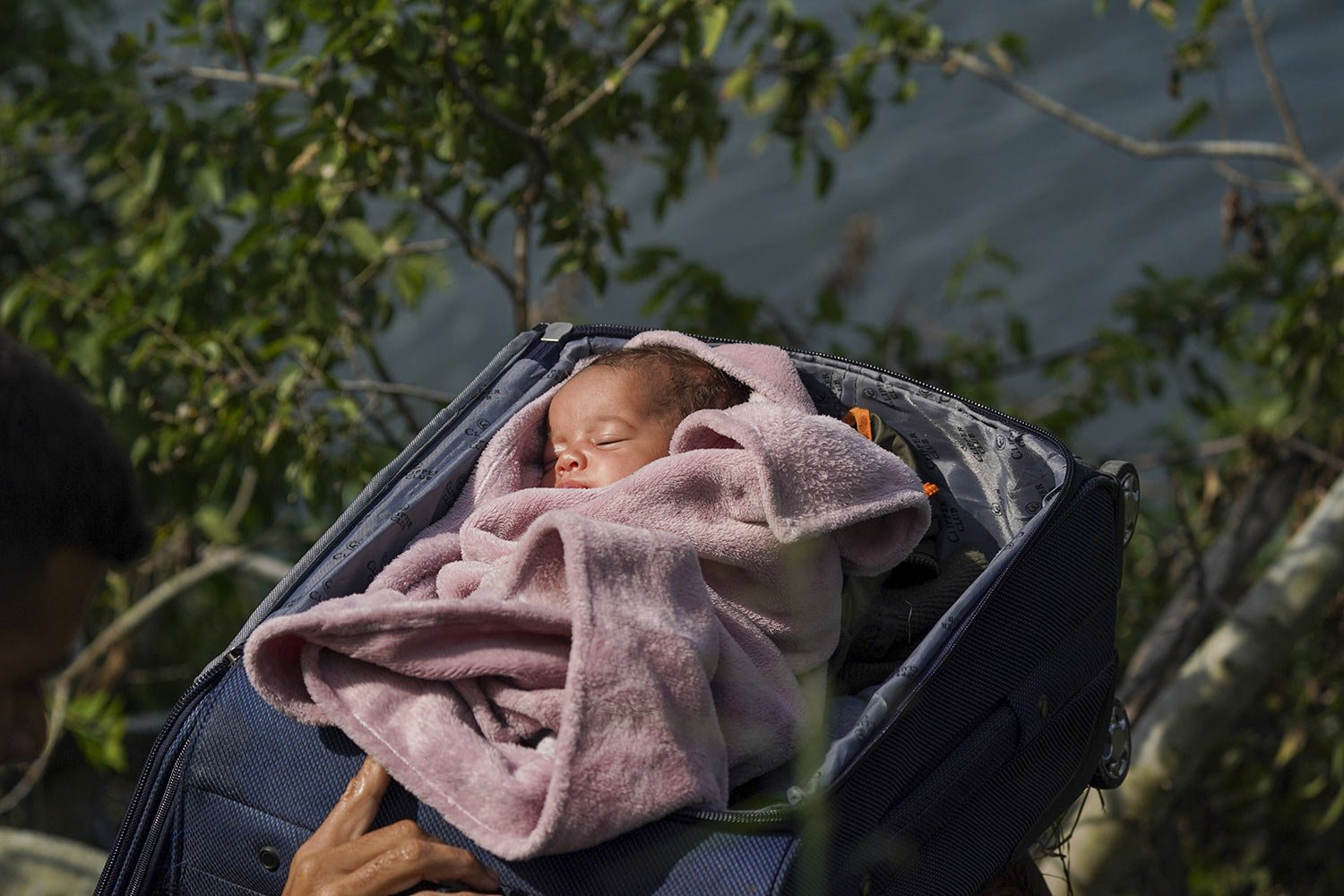 Migrants cross the Rio Grande into the U.S. with a baby in a suitcase, as seen from Matamoros, Mexico, May 10, 2023. (AP Photo/Fernando Llano) 