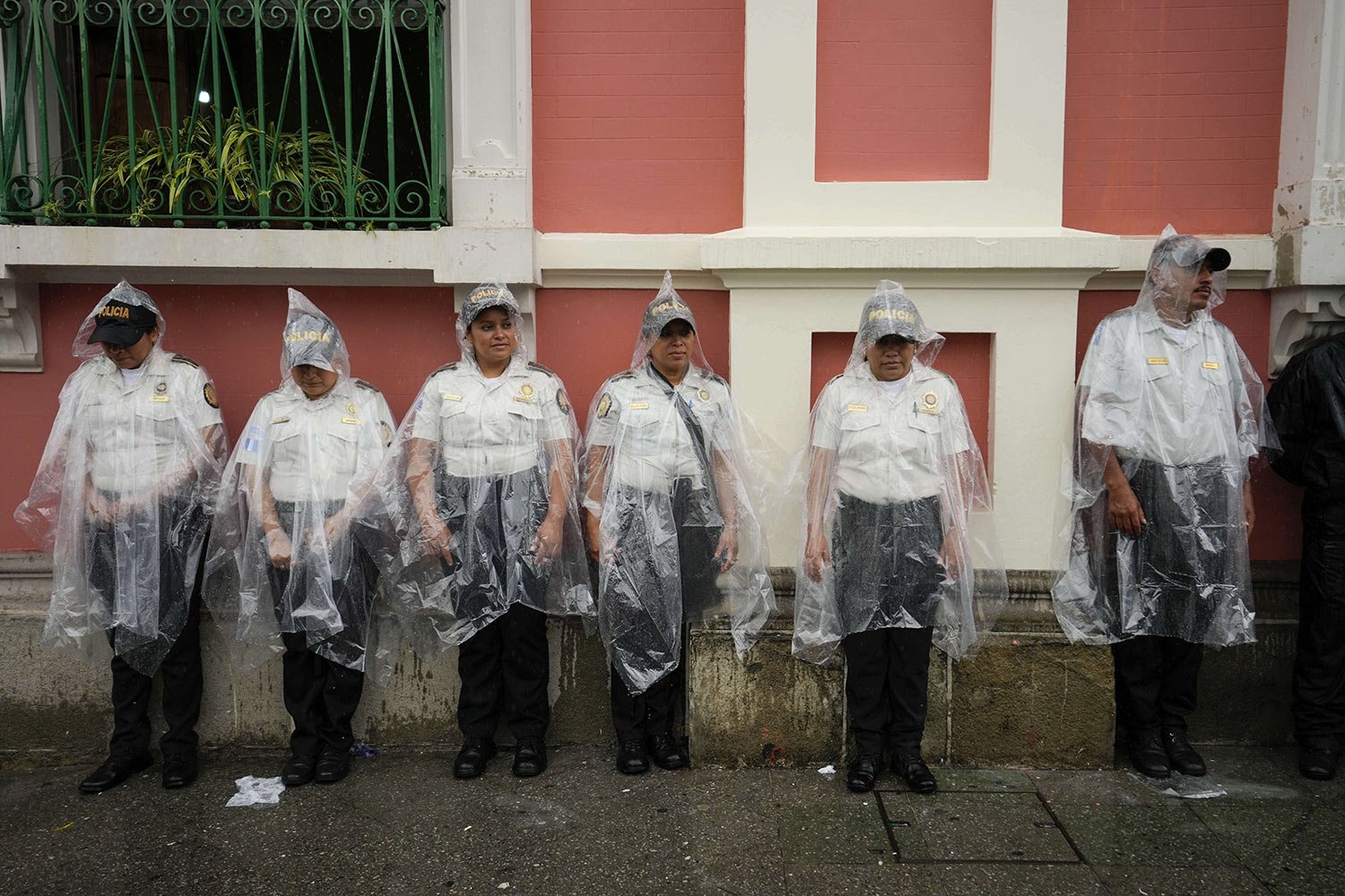  Police stand in the rain guarding the perimeters of the Electoral Court building as demonstrators march to support the electoral process in Guatemala City, July 8, 2023. (AP Photo/Moises Castillo) 
