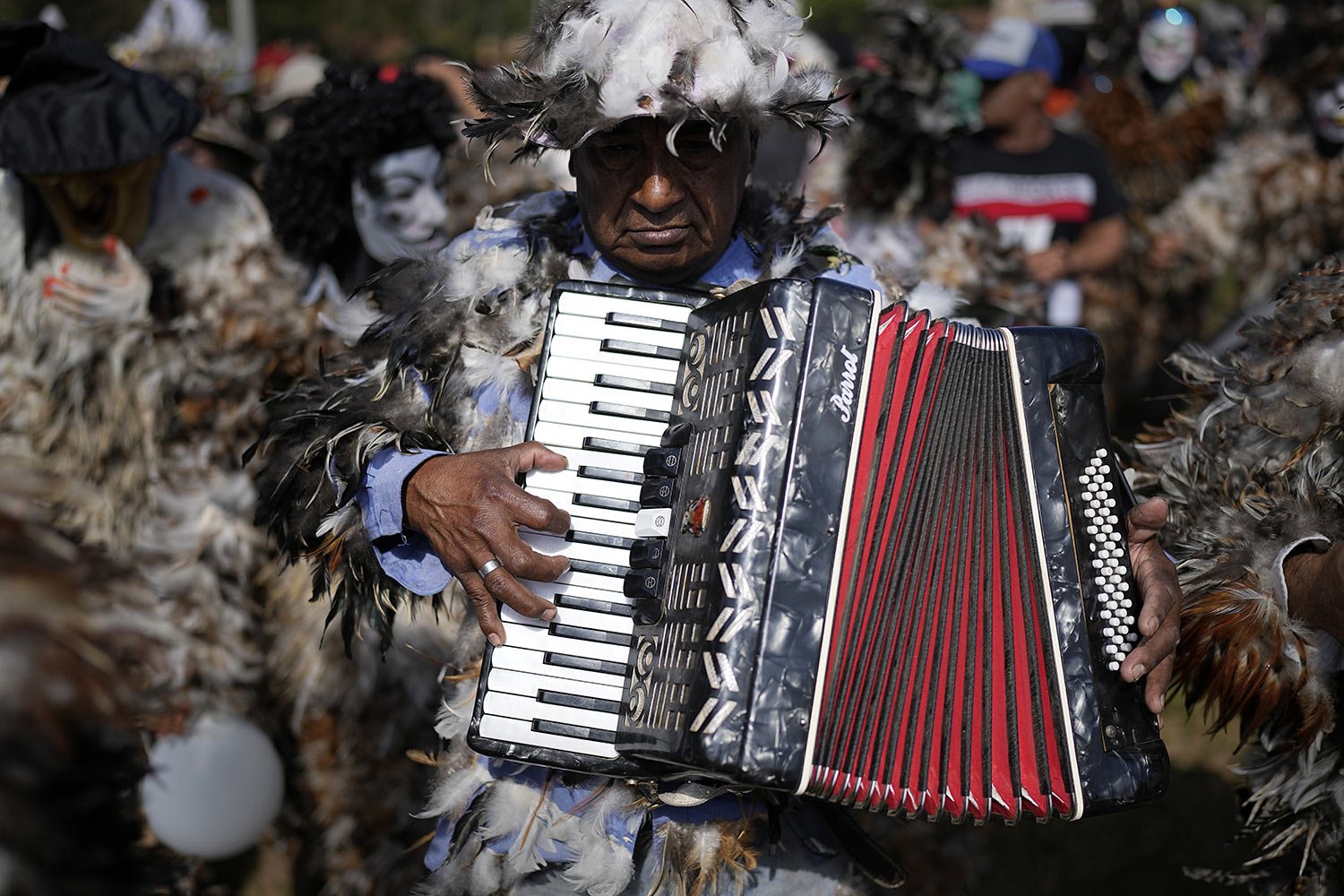  A devotee dressed in a feathered costume and playing an accordion pays tribute to Saint Francisco Solano for a fulfilled request, during a procession in the saint’s honor, in Emboscada, Paraguay, July 24, 2023. (AP Photo/Jorge Saenz) 