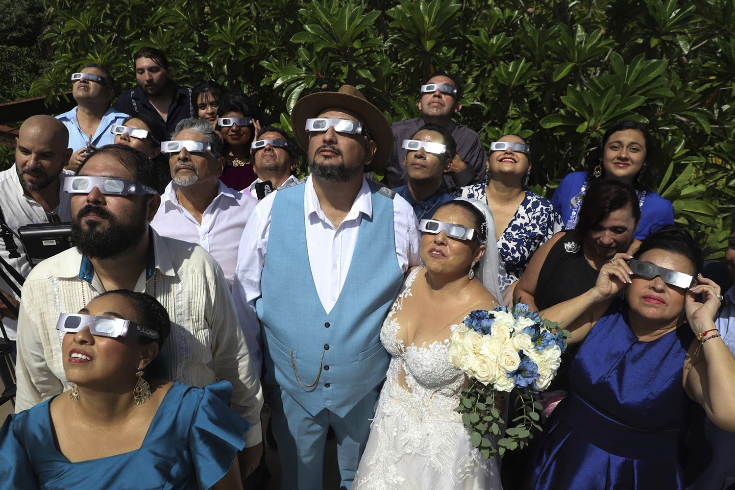  Groom Isaac Medina, center, and bride Jazmin Gonzalez, watch an annular solar eclipse, better known as a ring of fire, before the start of their wedding ceremony, in Merida, Mexico, Oct. 14, 2023. (AP Photo/Martin Zetina) 