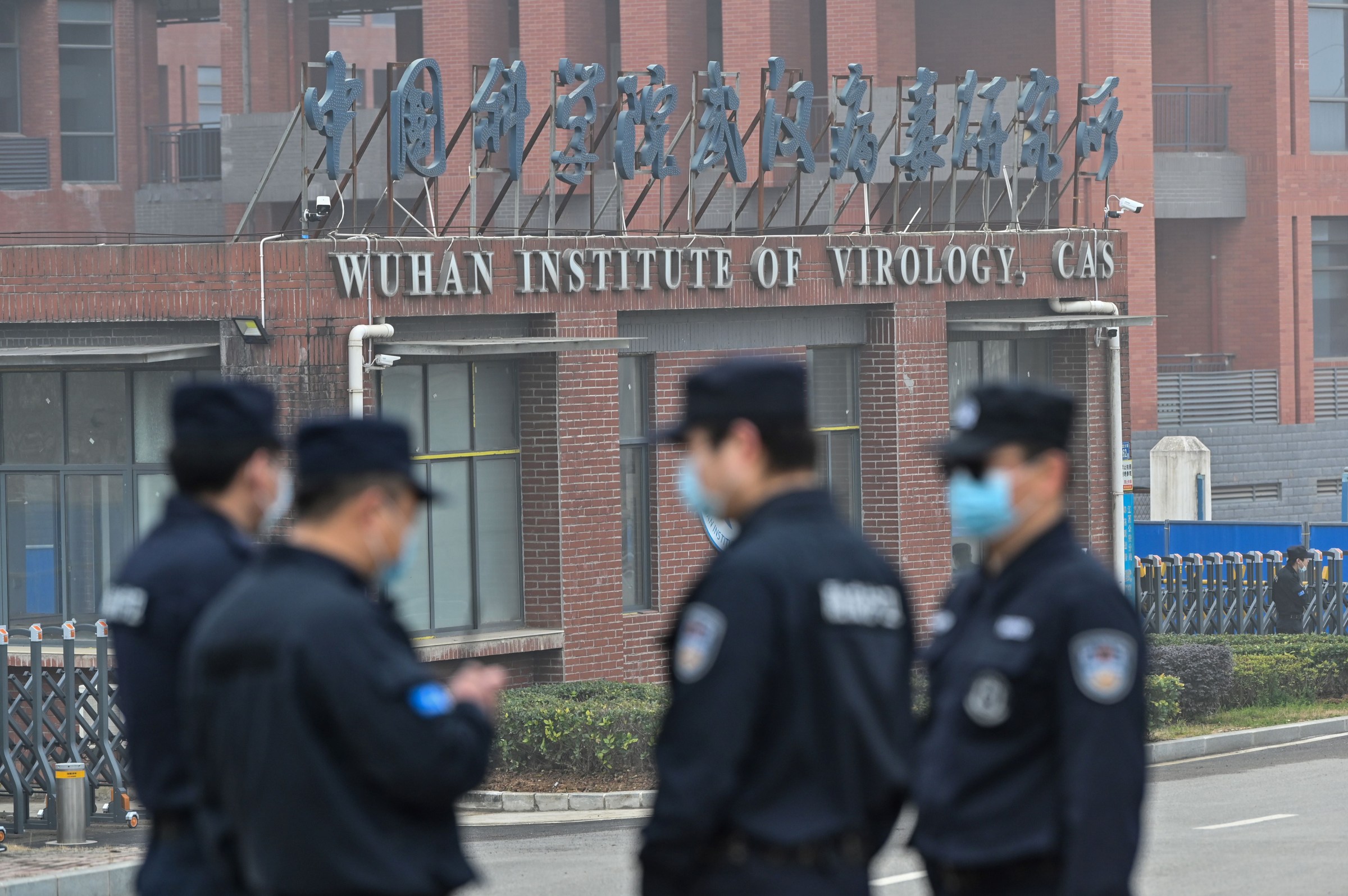 Security personnel stand guard outside the Wuhan Institute of Virology in Wuhan as members of the World Health Organization (WHO) team investigating the origins of the COVID-19 coronavirus make a visit to the institute in Wuhan in China’s central Hubei province on February 3, 2021. 