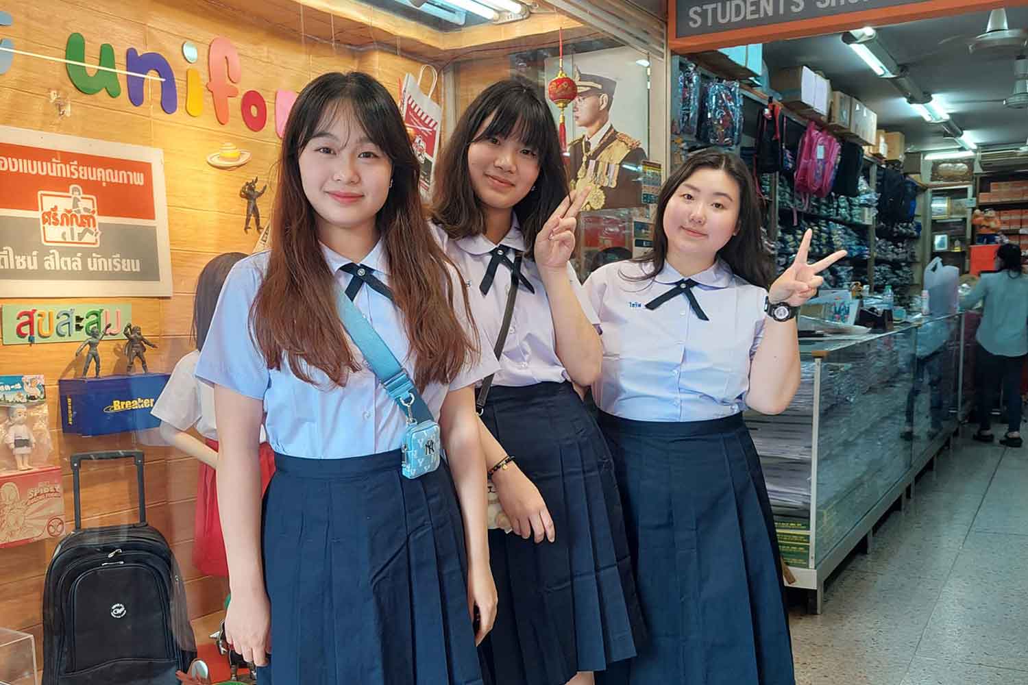 Chinese visitors model Thai student uniforms at the Sriphan shop in Bangkok. Store management posted the picture on its Facebook page last month and thanked the tourists for buying student uniforms there.