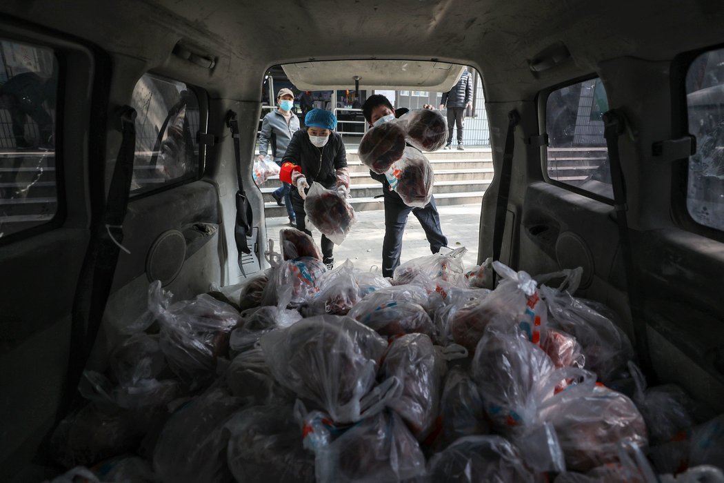 武汉的超市工作人员准备将一包包蔬菜送到市民手中。