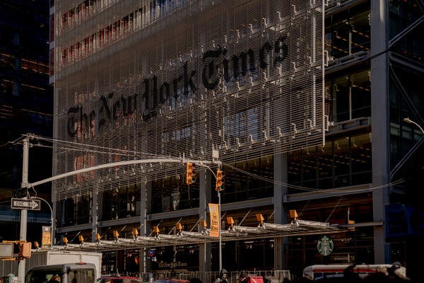 The New York Times building rises behind a city intersection. 